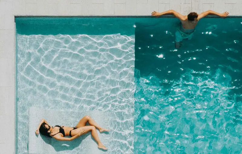 A couple resting under the sun in a swimming pool